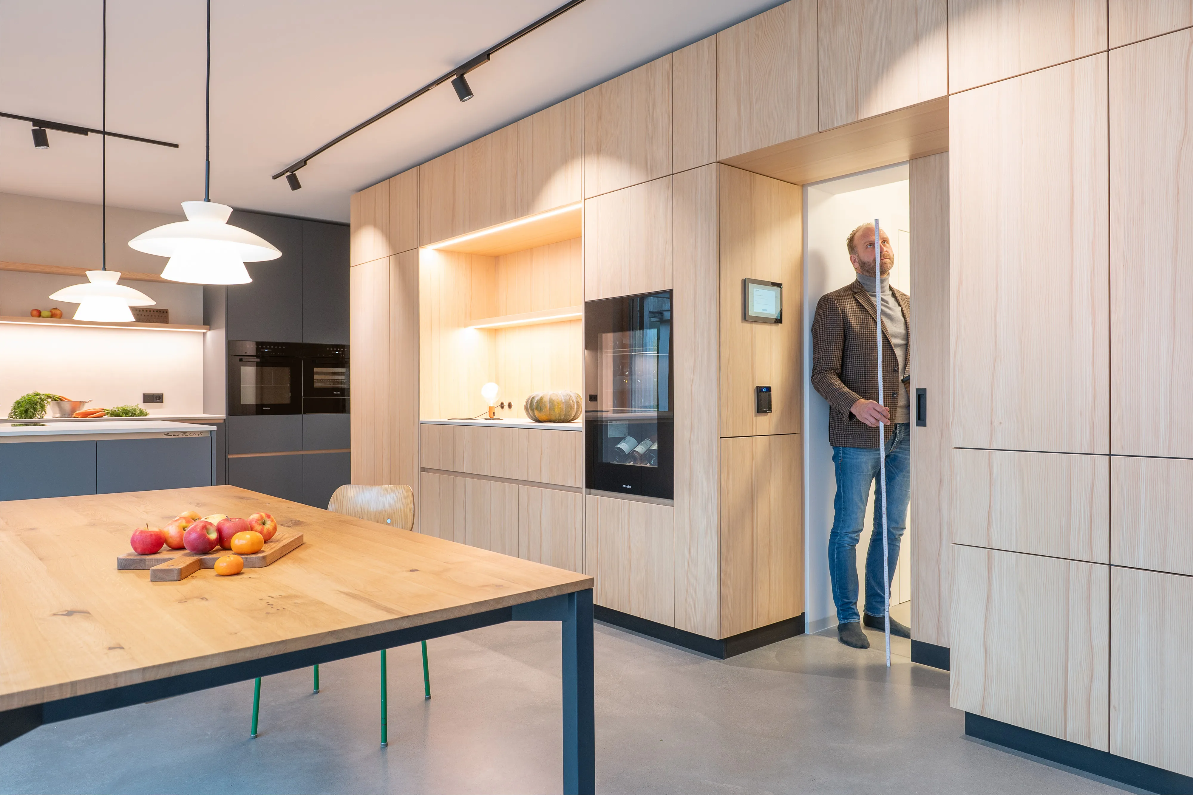 Maßgefertigte Schrankwand aus hellem Holz mit integrierter Schiebetür und Weinkühlschrank