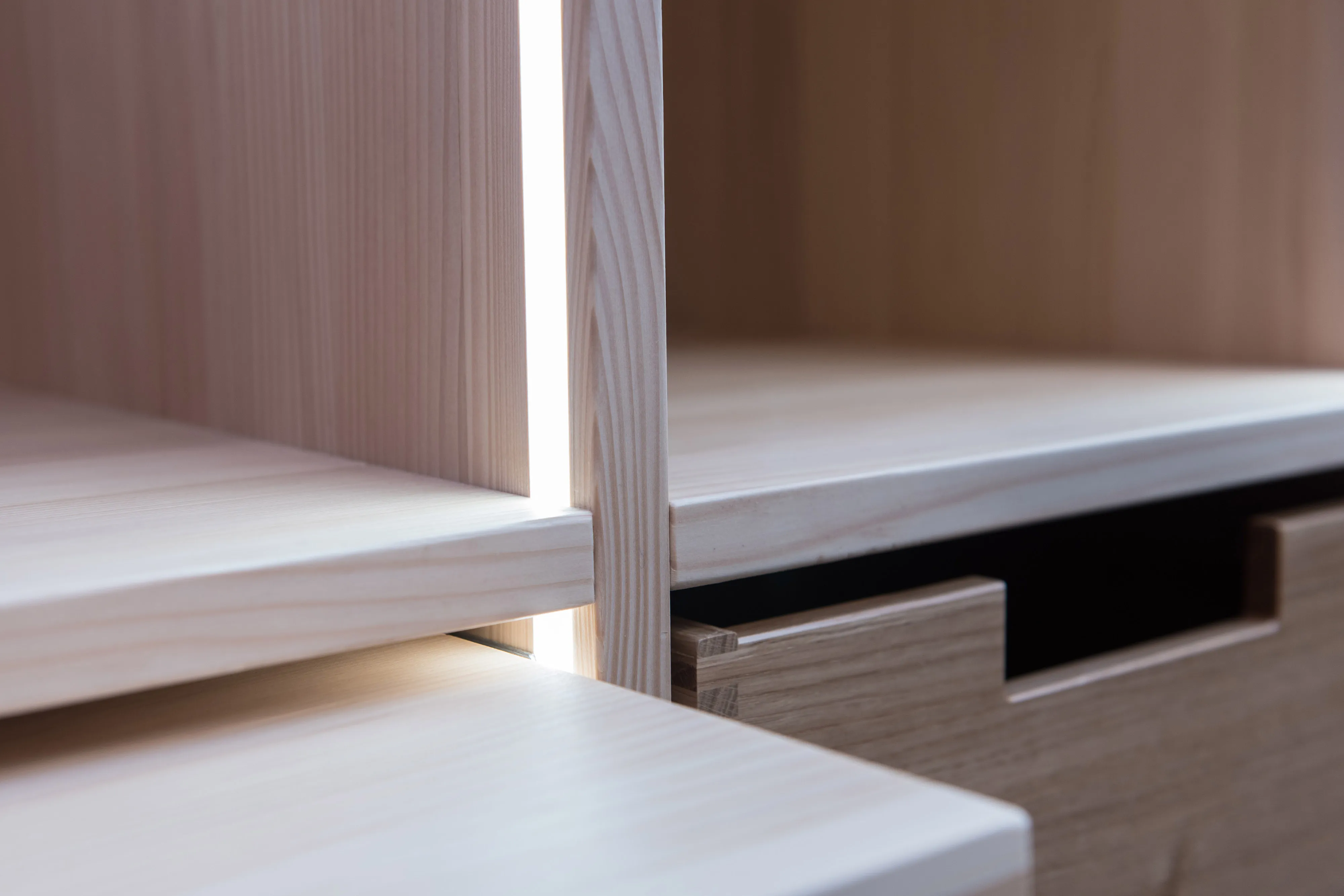 Detailaufnahme der Holzkonstruktion eines Maßschranks mit dezent integrierter LED-Lichtleiste